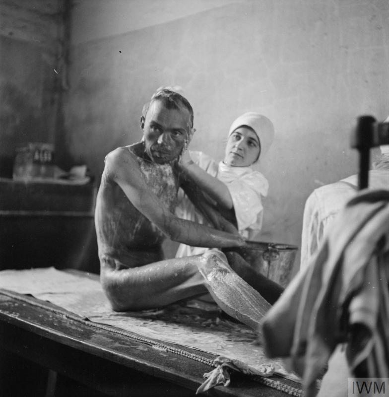 A camp survivor being washed in the 'human laundry'