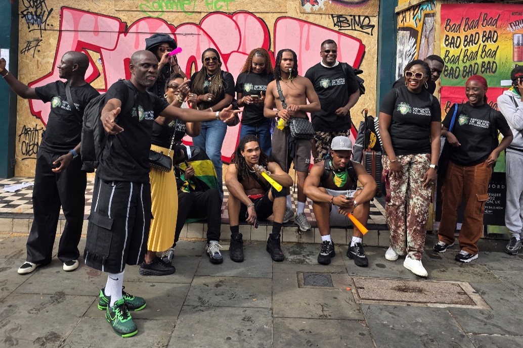 Group of people posing for a group shot on streets of London during Notting Hill Carnival