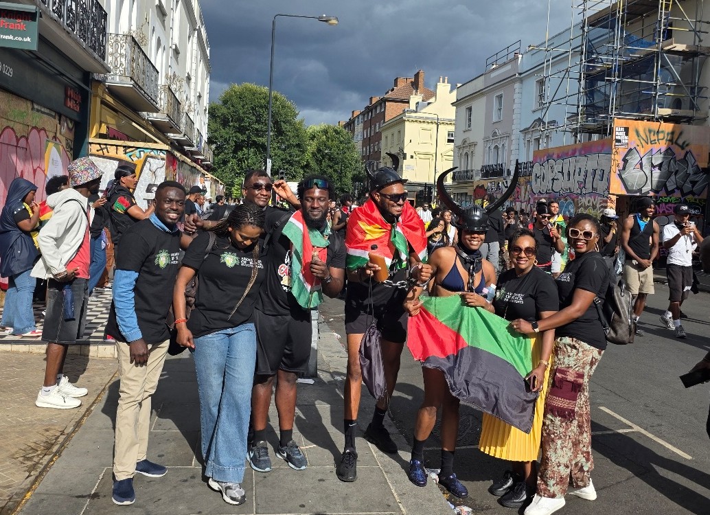 Group of people posing for a group shot on streets of London during Notting Hill Carnival