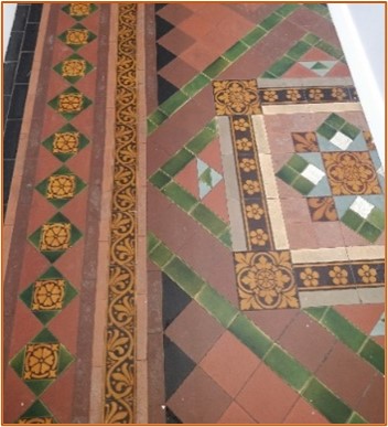 Fancy multicoloured tiles laid in patterns, some of which are decorated with scrollwork 