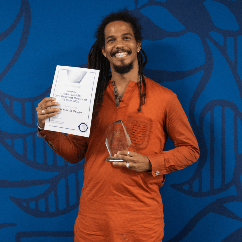 Martin Osugo holding a prize and certificate for winning the london division core resident doctor award