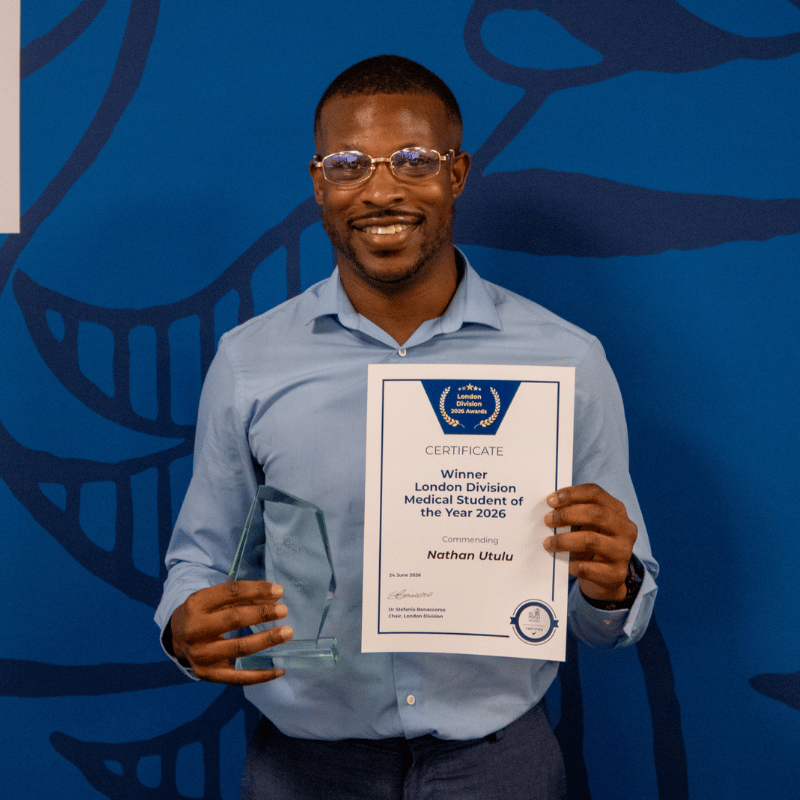Nathan Utulu holding award prize and certificate.