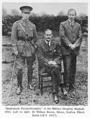 black and white photo of three white men, two in suits and one in WW1 era armed forces uniform